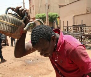 A file photo of a man pouring water on his head to quench the effects of a heatwave