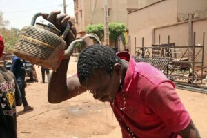 A file photo of a man pouring water on his head to quench the effects of a heatwave